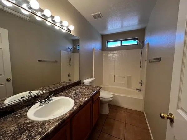 a bathroom with a granite countertop sink toilet and shower