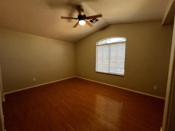 an empty room with a window and a ceiling fan