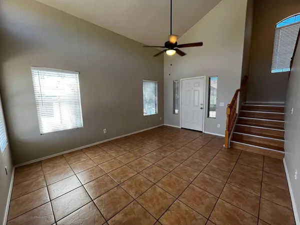 an empty room with windows and fan