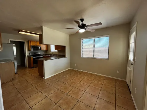 a kitchen with granite countertop a sink cabinets stainless steel appliances and a window