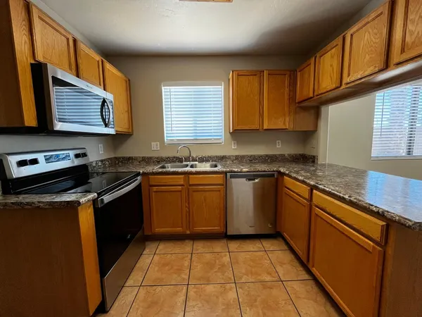 a kitchen with stainless steel appliances granite countertop a stove sink and cabinets