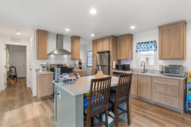 a kitchen with a dining table chairs and white cabinets