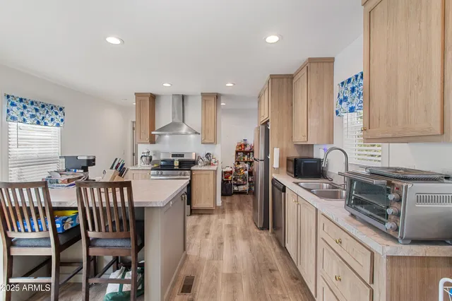 a kitchen with refrigerator a stove a sink and white cabinets