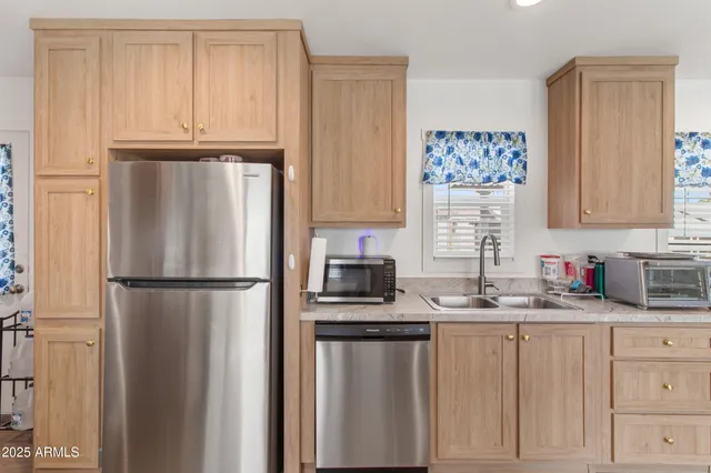 a kitchen that has a lot of cabinets a sink and appliances