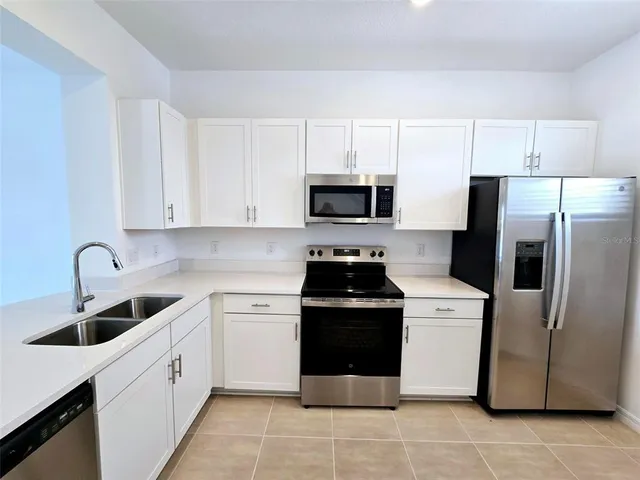 a kitchen with a white stove top oven and white stainless steel appliances