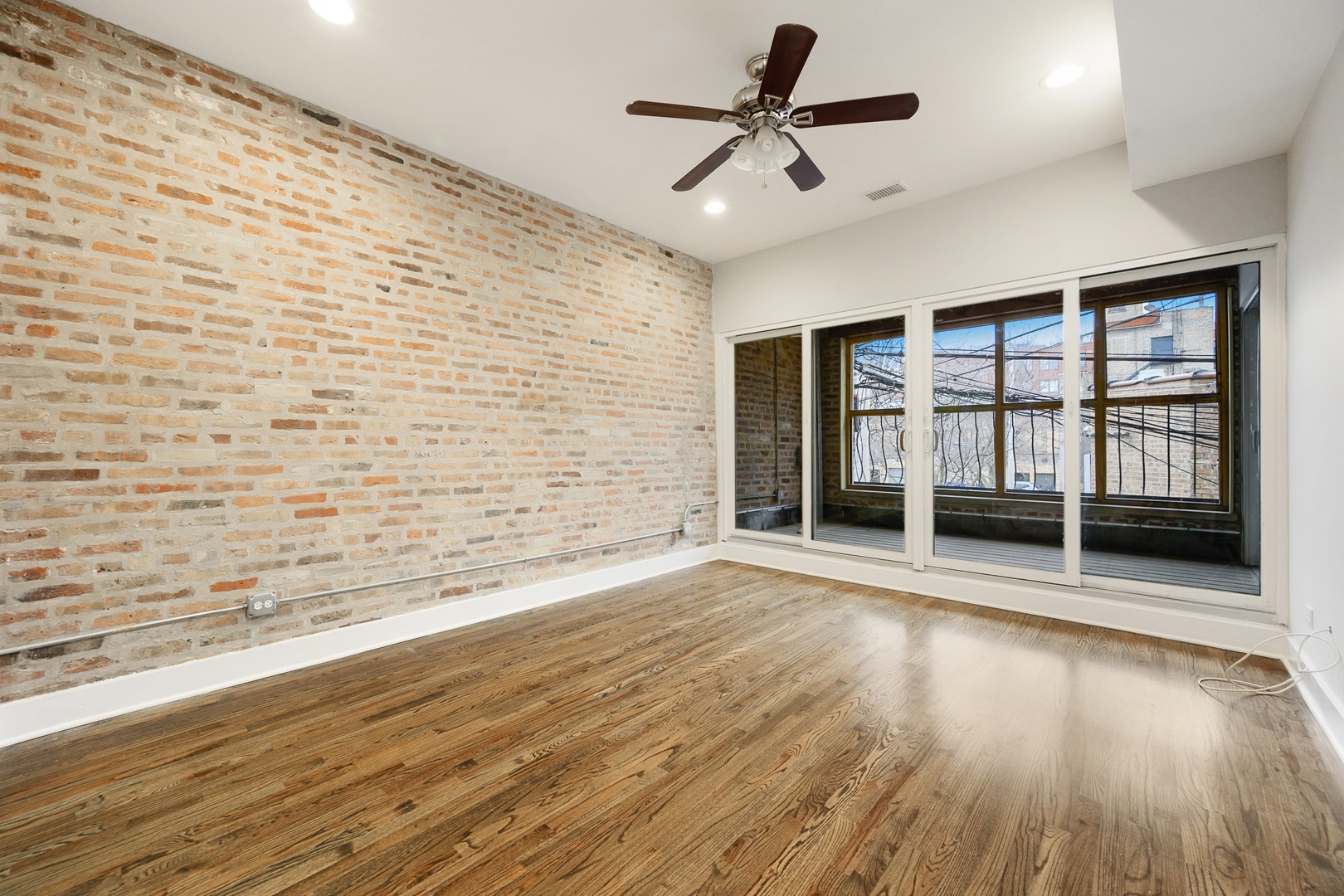 1015 West Lake Street, Unit 2E Chicago, IL 60607 - Photo 11 of 19 a view of empty room with wooden floor and fan