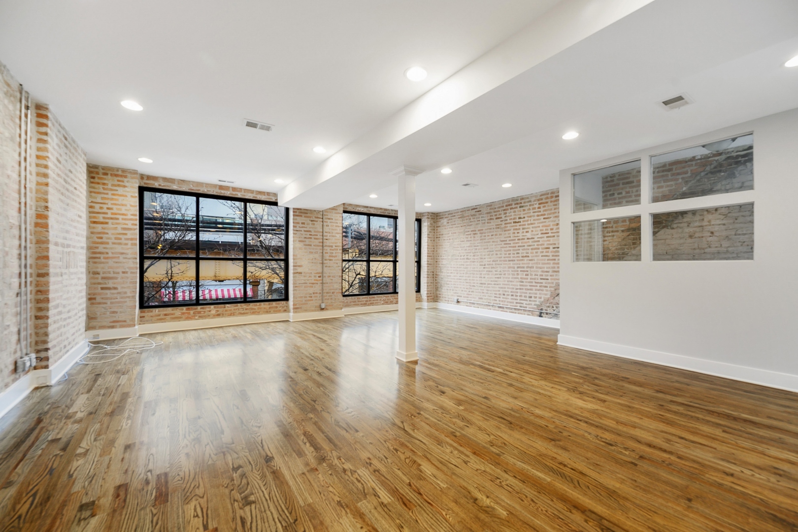 1015 West Lake Street, Unit 2E Chicago, IL 60607 - Photo 2 of 19 an empty room with wooden floor and windows
