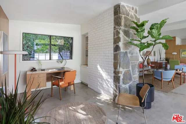a dining room with furniture and a potted plant