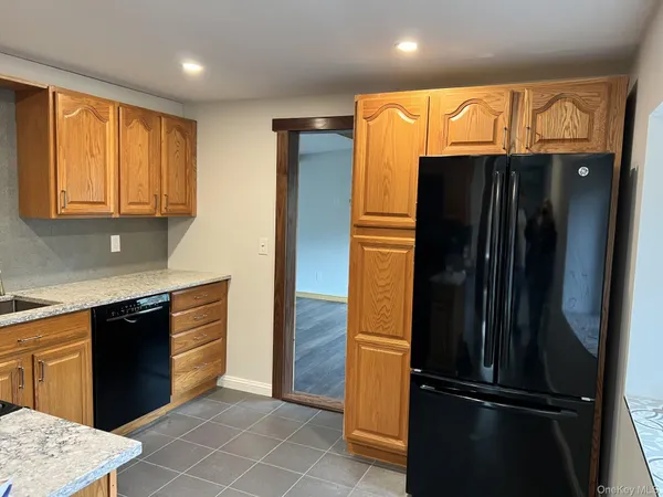 a kitchen with granite countertop stainless steel appliances and refrigerator