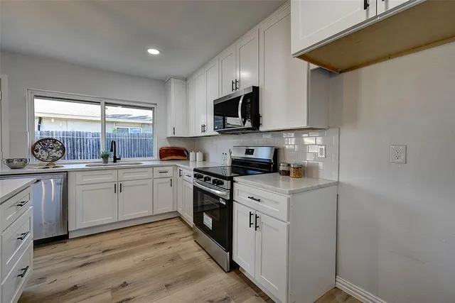 a kitchen with stainless steel appliances granite countertop a stove a sink and a microwave