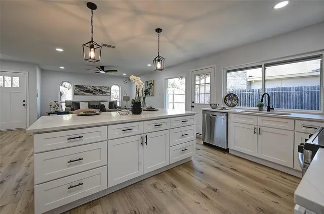 a kitchen with counter top sink and cabinets