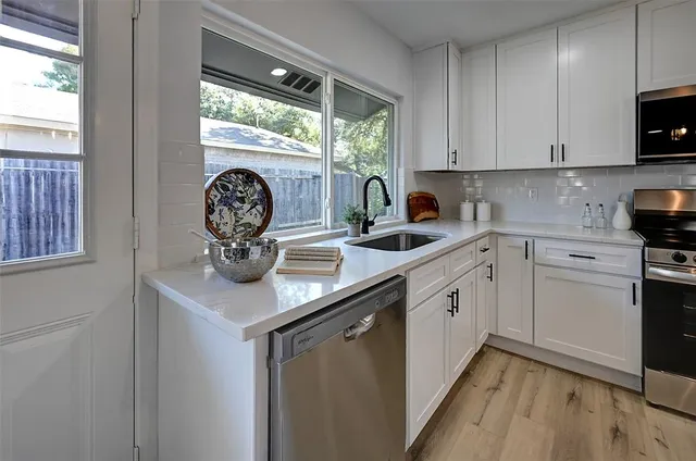 a kitchen with stainless steel appliances granite countertop a sink and a stove top oven