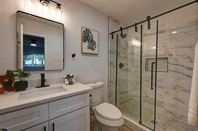a bathroom with a sink a toilet and shower