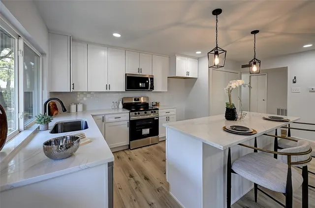 a kitchen with a sink a stove and chairs