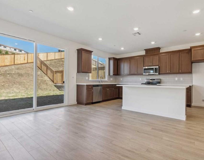 8094 Waterfall Lane Vallejo, CA 94591 - Photo 7 of 13 a large kitchen with stainless steel appliances granite countertop a stove a sink and a microwave