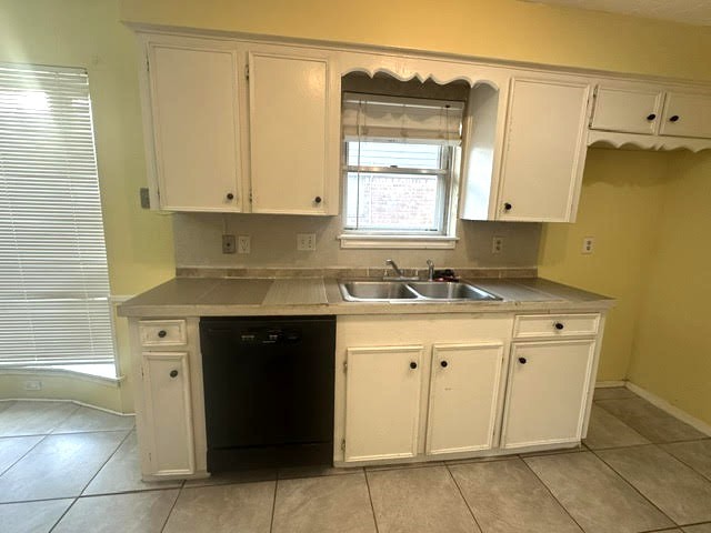 12331 Scarcella Lane Meadows Place, TX 77477 - Photo 2 of 13 This kitchen features a classic design. It has tiled flooring and a window above the sink for natural light.