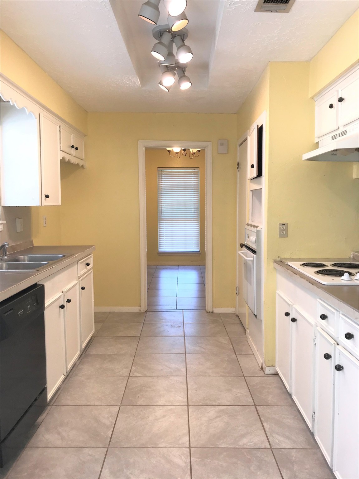 12331 Scarcella Lane Meadows Place, TX 77477 - Photo 3 of 13 Bright kitchen. Features include tile flooring, a double sink, oven, and stovetop. Ample lighting and a window provide natural light.