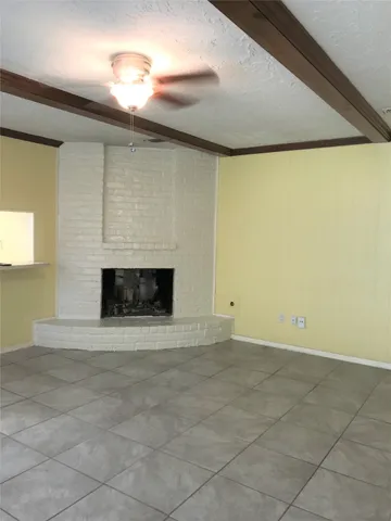 a view of empty room with a fireplace and fan