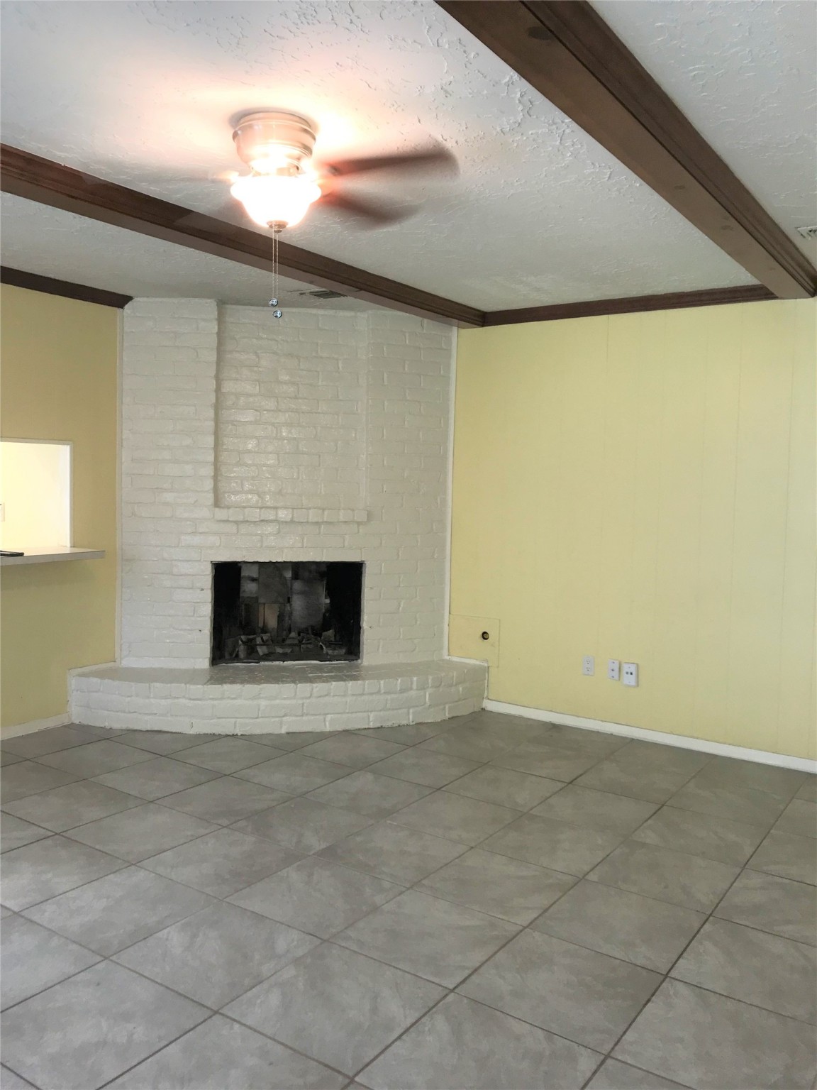 12331 Scarcella Lane Meadows Place, TX 77477 - Photo 4 of 13 This room features a cozy corner with a brick fireplace, tile flooring, and a ceiling fan.
