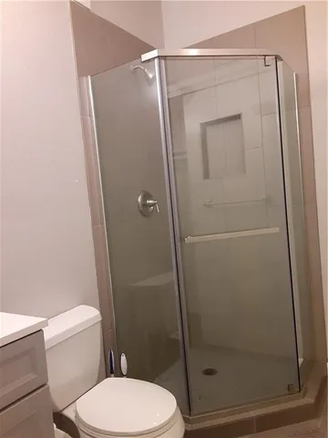 a white toilet sitting next to a shower