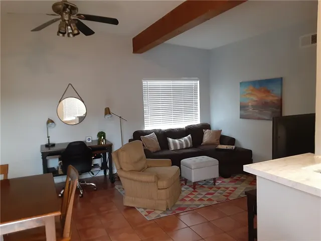 a living room with furniture a chandelier and a window