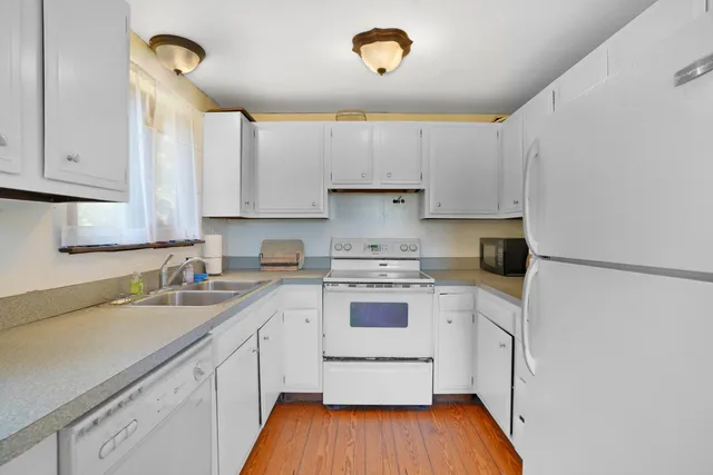 a kitchen with a white cabinets and white appliances