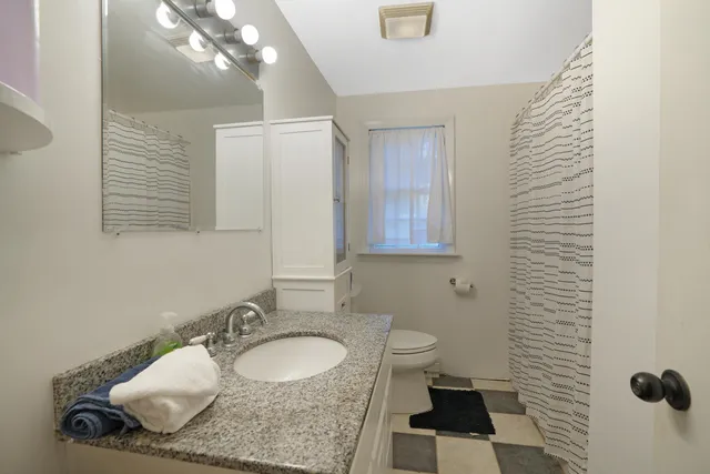 a bathroom with a sink toilet and mirror