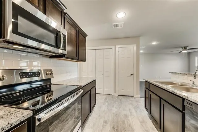 a kitchen with stainless steel appliances granite countertop a stove and a microwave