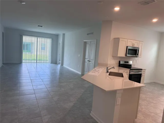 a kitchen with a sink a stove top oven a chimney and a window