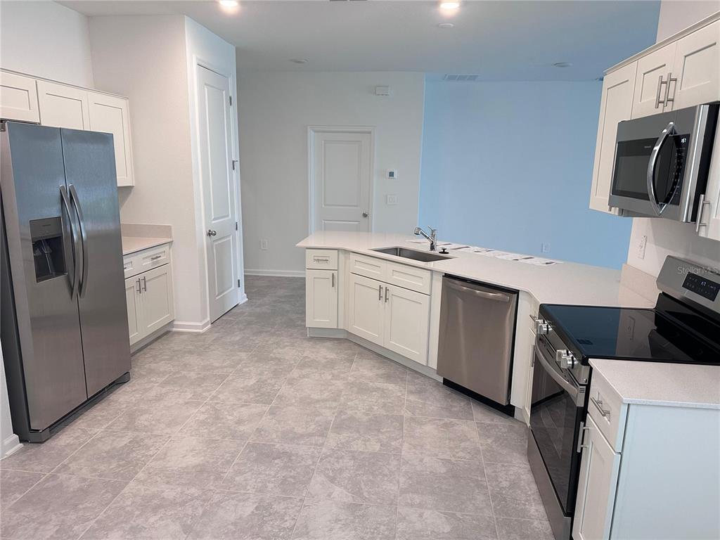 1760 Foreman Road Eagle Lake, FL 33839 - Photo 4 of 22 a kitchen with a sink stove and refrigerator