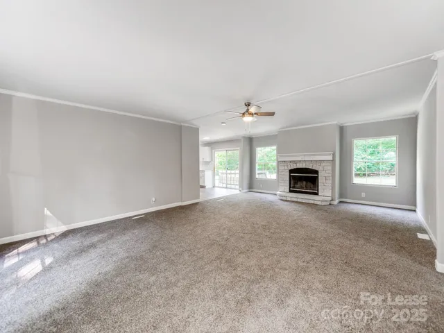 an empty room with windows and fireplace