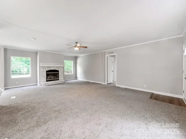 an empty room with fireplace and windows