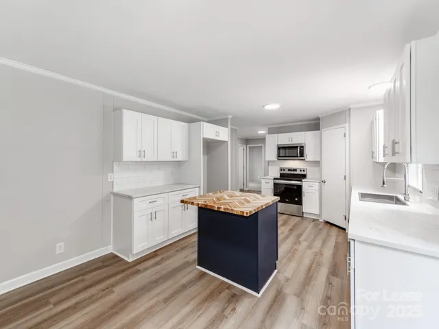 a large bathroom with a granite countertop double vanity sink a mirror and a bathtub