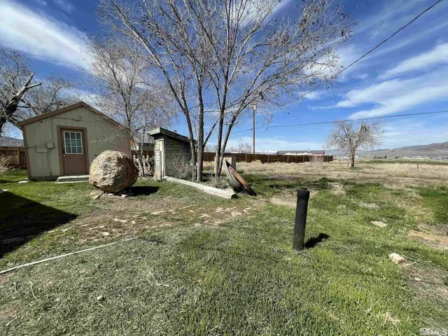 a view of a backyard with table and chairs and a fire pit