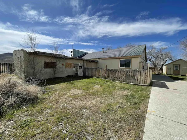 a backyard of a house with table and chairs