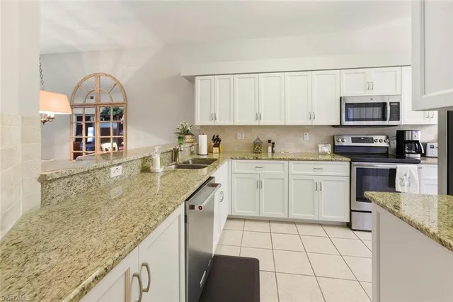 a kitchen with stainless steel appliances granite countertop a sink a stove top oven a counter space and cabinets