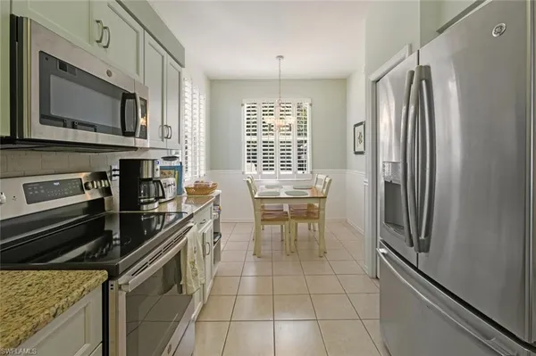 a kitchen with a refrigerator and a stove top oven