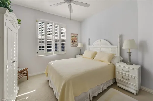 a bedroom with a bed a chandelier and a window