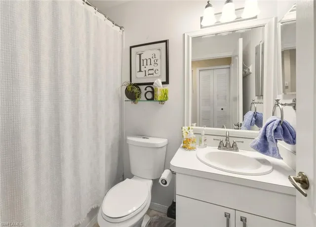 a bathroom with a toilet a sink and a mirror