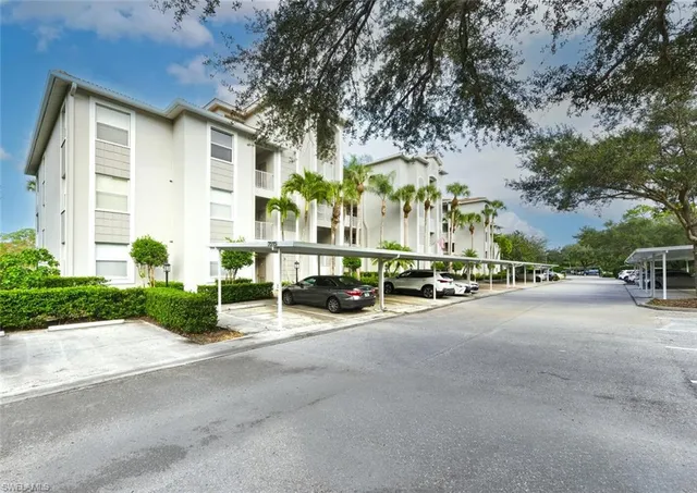 a view of a street with a building and palm trees