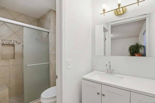 a bathroom with a sink a toilet and shower