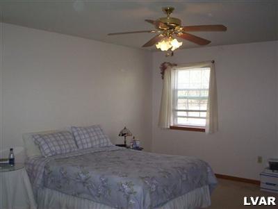 145 Little Twig Road Effort, PA 18330 - Photo 8 of 8 a bedroom with a bed and a chandelier