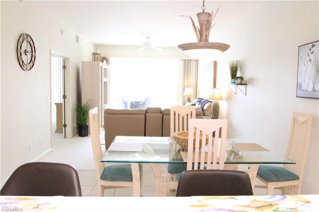 6660 Beach Resort Drive, Unit 1005 Naples, FL 34114 - Photo 16 of 38 a living room with furniture a table and a large window