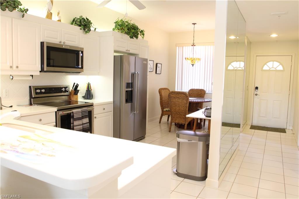 6660 Beach Resort Drive, Unit 1005 Naples, FL 34114 - Photo 18 of 38 a kitchen with refrigerator and microwave