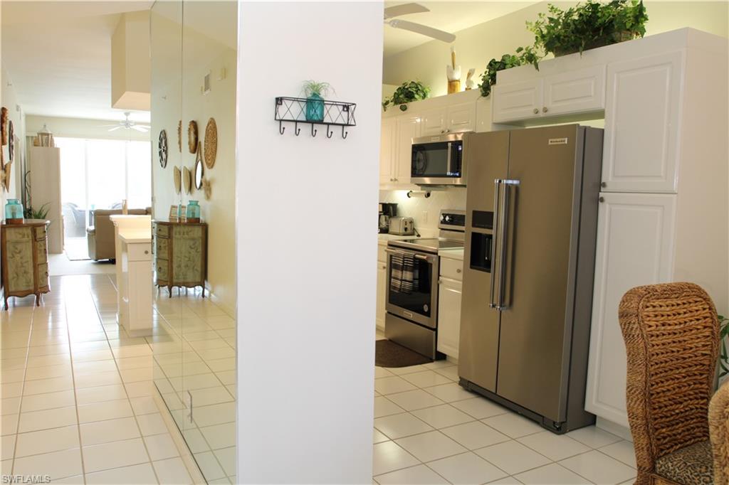 6660 Beach Resort Drive, Unit 1005 Naples, FL 34114 - Photo 19 of 38 a kitchen with stainless steel appliances granite countertop a refrigerator and a stove