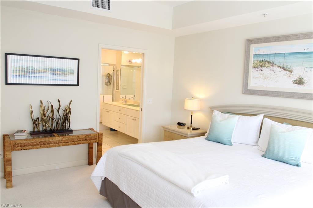 6660 Beach Resort Drive, Unit 1005 Naples, FL 34114 - Photo 2 of 38 a bedroom with a bed and lamp
