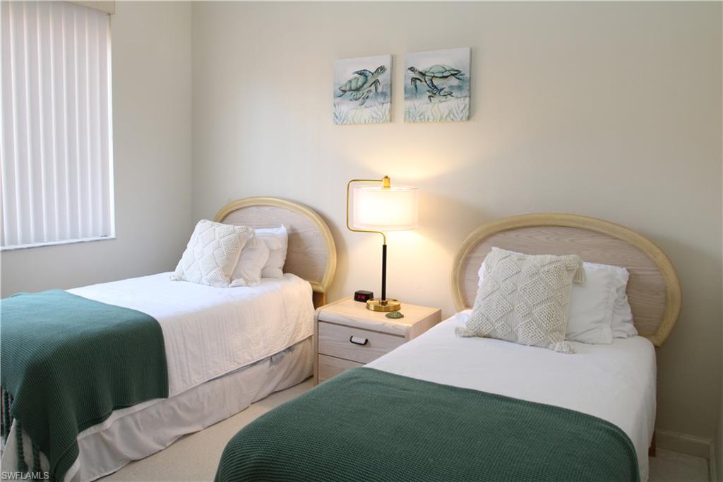 6660 Beach Resort Drive, Unit 1005 Naples, FL 34114 - Photo 24 of 38 a bedroom with two beds and painting on the wall