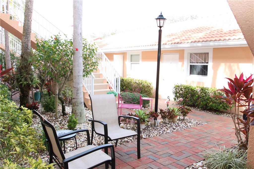 6660 Beach Resort Drive, Unit 1005 Naples, FL 34114 - Photo 33 of 38 a backyard of a house with table and chairs