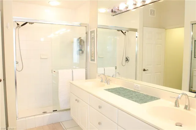 a bathroom with a granite countertop sink shower and a mirror