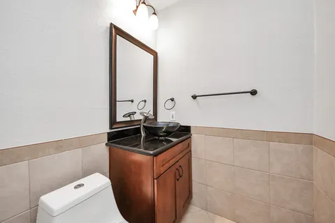 a bathroom with a granite countertop sink and a toilet